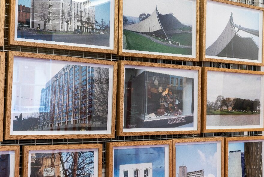 A wall covered in framed images and photographs and displayed very close together.