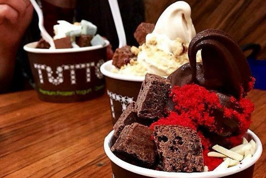 Tutto frozen yogurt dessert in a cup with squares of chocolate cake.